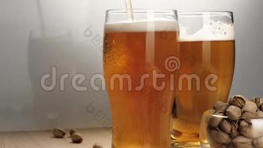新鲜啤酒。 在白色背景的木桌上，用手将美<strong>味</strong>的冰镇啤酒和一些开心果倒入啤酒杯<strong>碟</strong>中